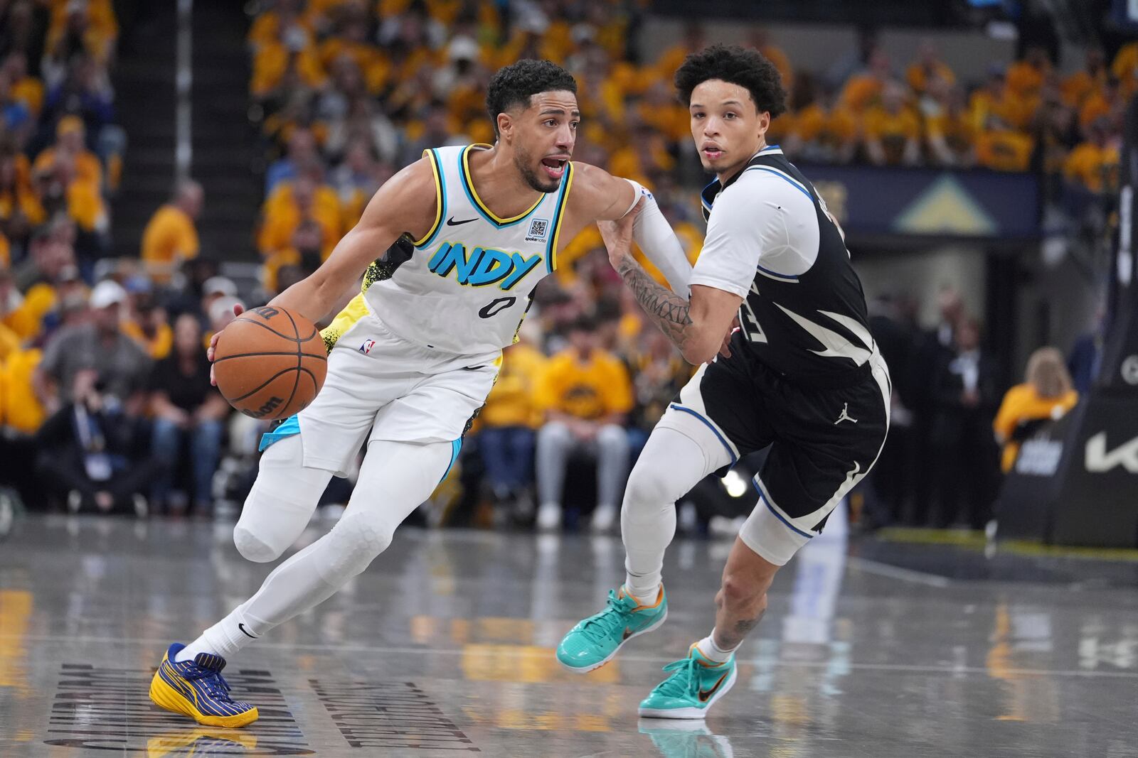 Indiana Pacers' Tyrese Haliburton (0) drives past Milwaukee Bucks' Ryan Rollins during the first half of a first-round NBA basketball playoff game, Saturday, April 19, 2025, in Indianapolis. (AP Photo/Michael Conroy)