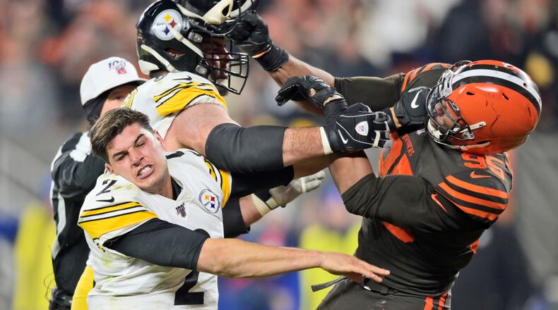 Cleveland Browns defensive end Myles Garrett (95) hits Pittsburgh Steelers quarterback Mason Rudolph (2) with a helmet during the second half of an NFL football game Thursday, Nov. 14, 2019, in Cleveland. (AP Photo/David Richard)