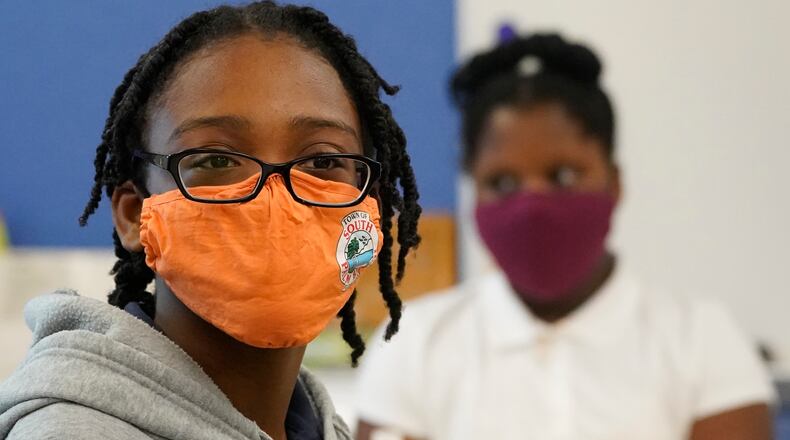 Students wear masks to help prevent the spread of COVID-19 as they listen during class, Tuesday, Aug. 10, 2021, during the first day of school at Washington Elementary School in Riviera Beach, Fla. (AP Photo/Wilfredo Lee)
