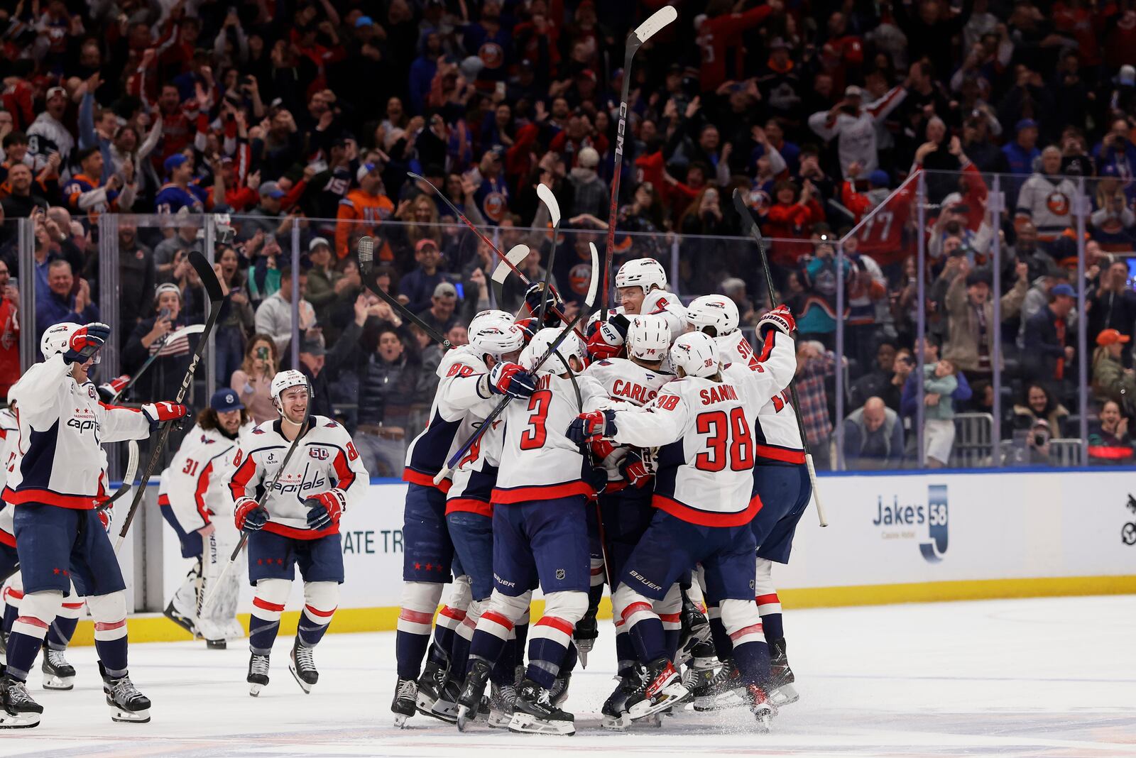 Washington Capitals left wing Alex Ovechkin (8) celebrates with teammates after scoring against New York Islanders during the second period of an NHL hockey game in Elmont, N.Y., Sunday, April 6, 2025. (AP Photo/Adam Hunger)