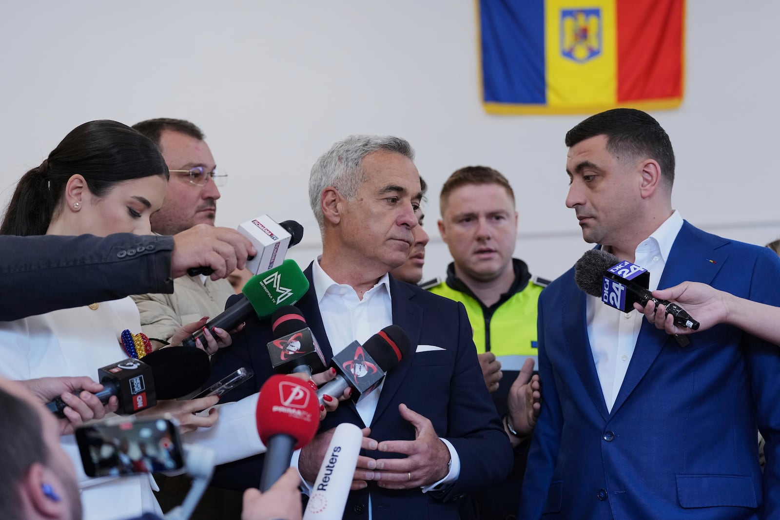 Presidential candidate George Simion, right, and Calin Georgescu, winner of the first round of last year's annulled election, speak to media after casting their votes in the second round of the country's presidential election redo in Mogosoaia, Romania, Sunday, May 18, 2025. (AP Photo/Andreea Alexandru)