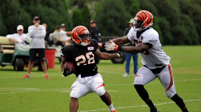 Cincinnati Bengals defensive end Michael Johnson stops Joe Mixon in the backfield during practice Monday. JAY MORRISON/STAFF