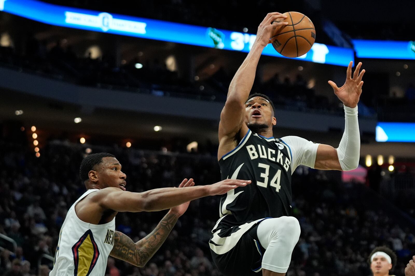 Milwaukee Bucks' Giannis Antetokounmpo (34) drives to the basket against New Orleans Pelicans' Jamal Cain, left, during the first half of an NBA basketball game Thursday, April 10, 2025, in Milwaukee. (AP Photo/Aaron Gash)