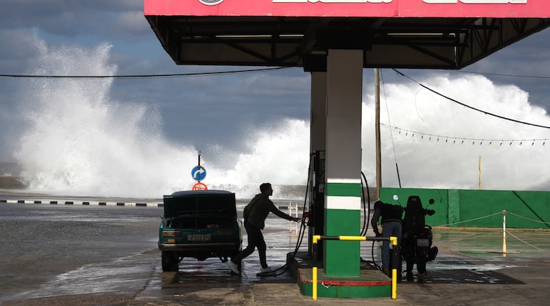 People refuel their car and motorcycle at a gas station near the Malecon in Havana, Cuba, Tuesday, Jan. 27, 2026. (AP Photo/Ramon Espinosa)