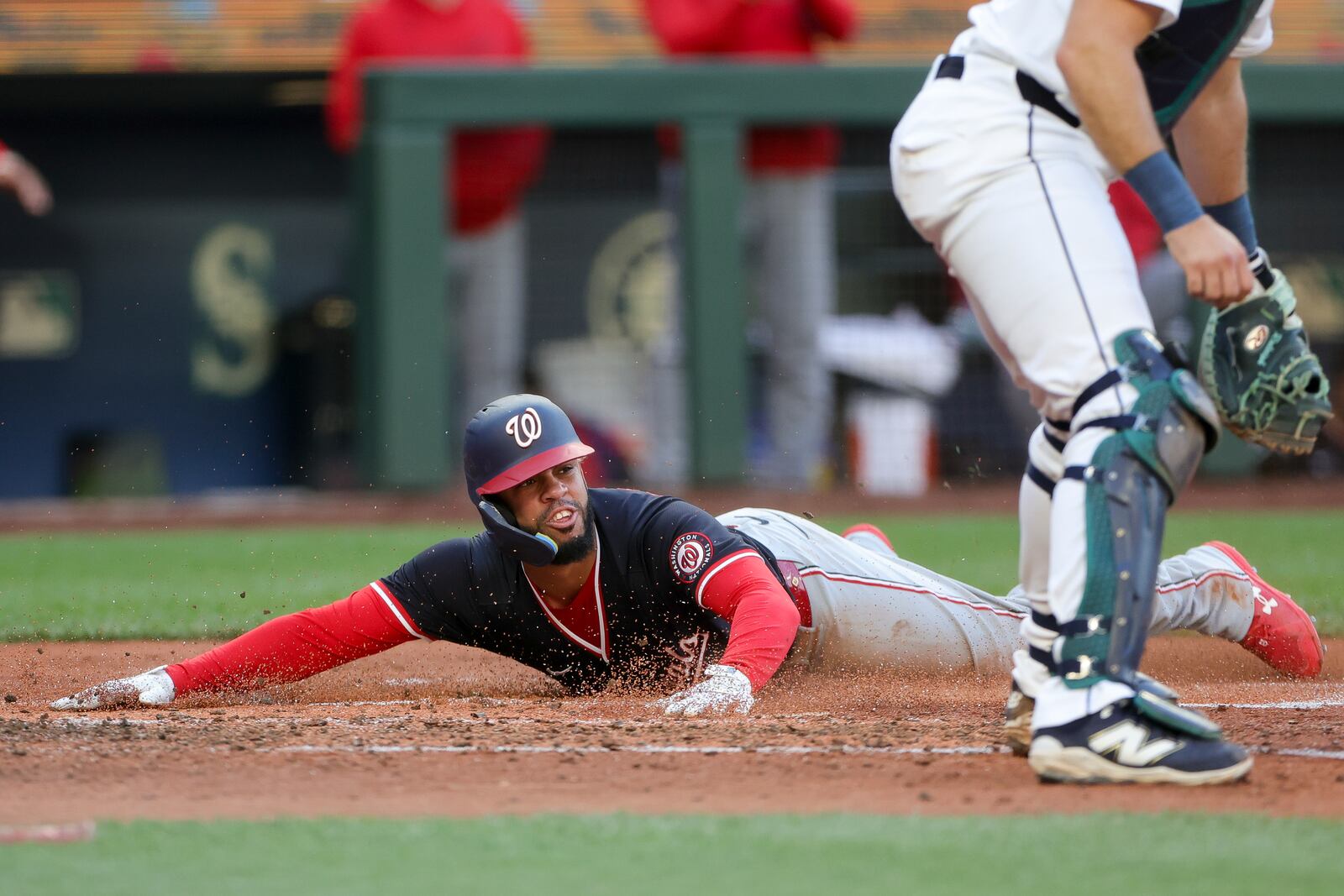 Washington Nationals' Luis Garcia Jr. slides home to score past Seattle Mariners catcher Cal Raleigh off a single hit by Robert Hassell III during the fourth inning of a baseball game Wednesday, May 28, 2025, in Seattle. (AP Photo/Ryan Sun)