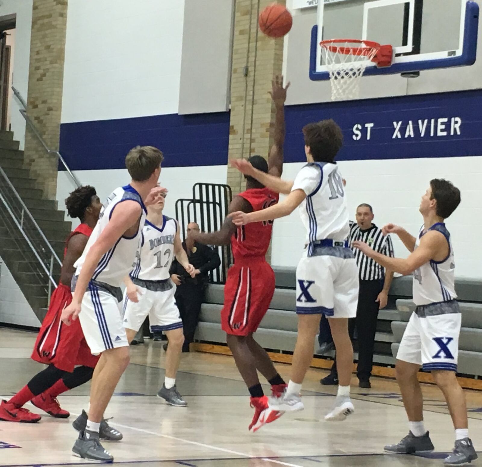 Lakota West’s Myles Greenwood (15) puts up a shot over St. Xavier’s Nathan Stockman (10) during Tuesday night’s game at Berning Gym in Springfield Township. RICK CASSANO/STAFF