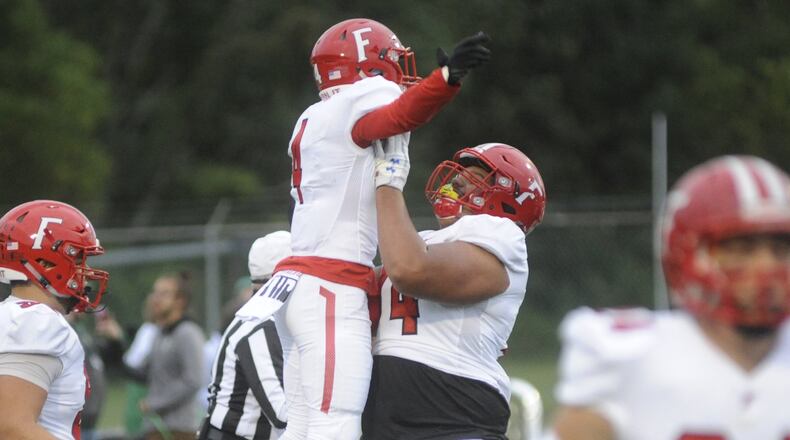 Fairfield’s Raqwon Williams (left) is hoisted by teammate Jack Carman after Williams scored on a 63-yard punt return during Friday night’s game at Northmont. The host Thunderbolts rallied for a 28-21 victory. MARC PENDLETON/STAFF