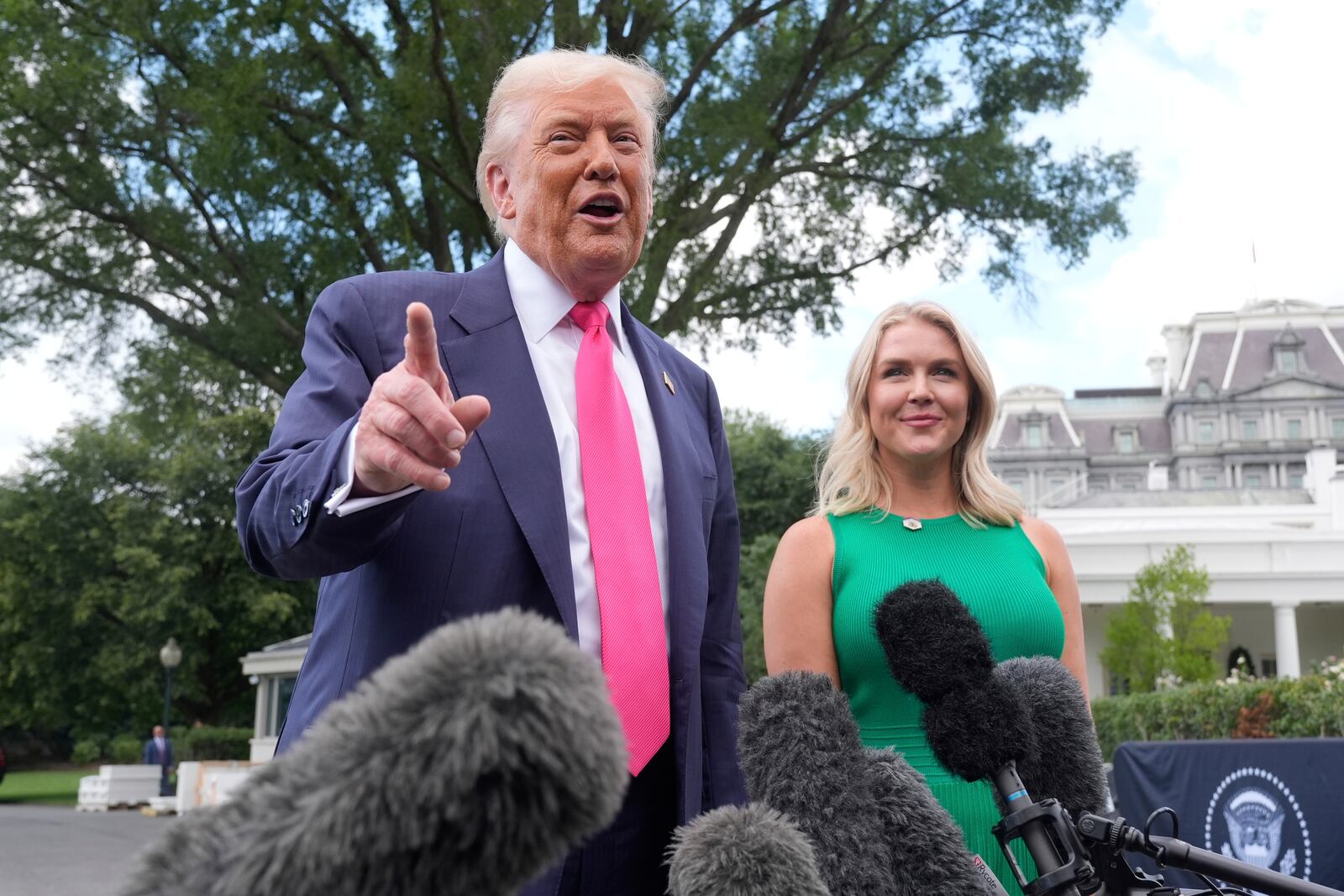 President Donald Trump speaks to the media as he leaves the White House, Tuesday, July 15, 2025, in Washington, as White House press secretary Karoline Leavitt, looks on. (AP Photo/Manuel Balce Ceneta)
