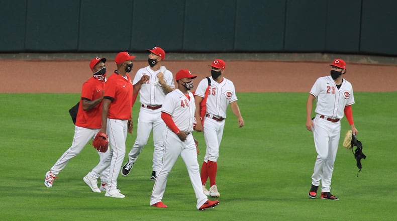 Reds relievers, including Cody Reed, far left, walk back to the dugout after a game on July 24, 2020, at Great American Ball Park in Cincinnati. David Jablonski/Staff