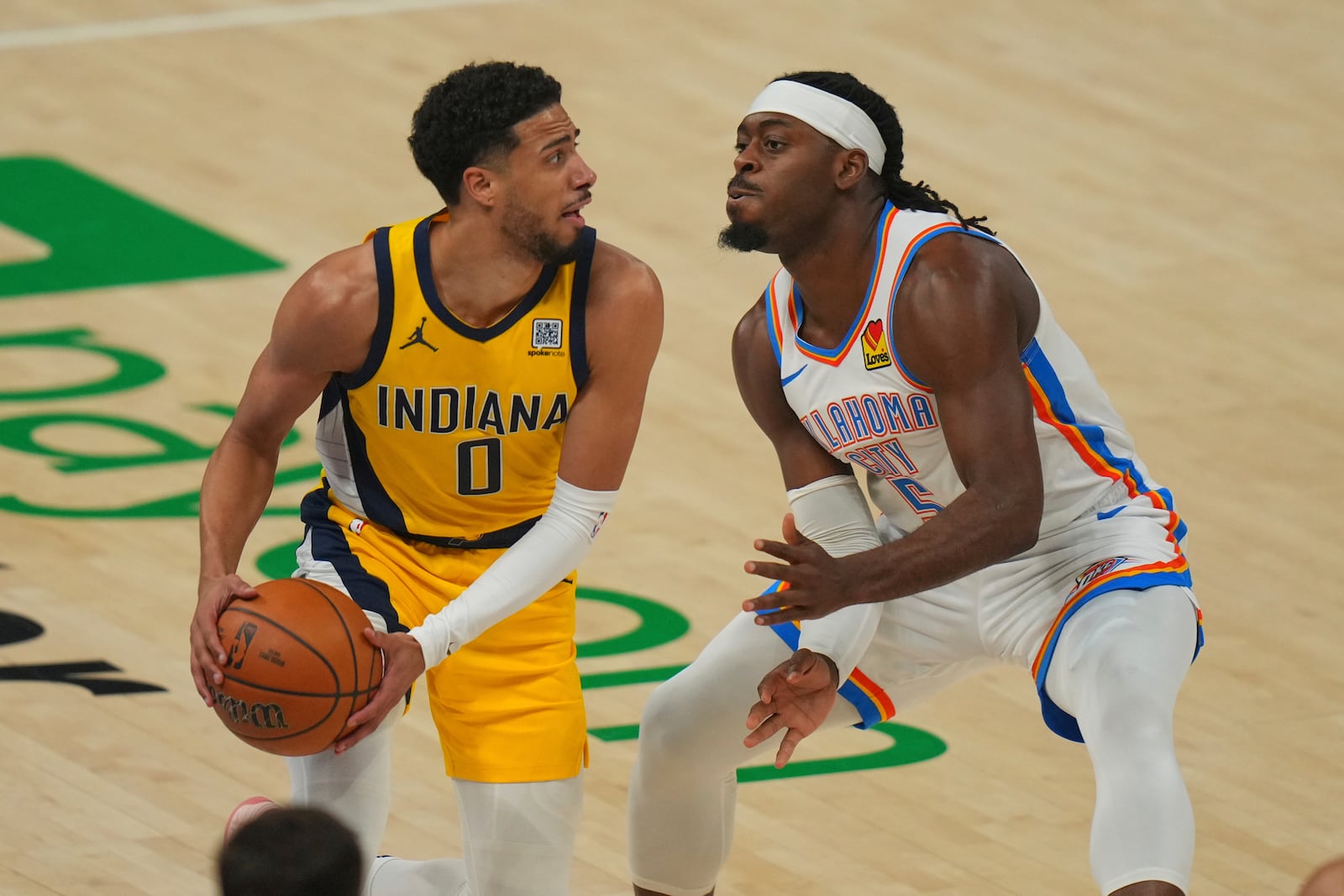 Indiana Pacers guard Tyrese Haliburton (0) looks to pass under pressure from Oklahoma City Thunder guard Luguentz Dort (5) during the first half of Game 5 of the NBA Finals basketball series, Monday, June 16, 2025, in Oklahoma City. (AP Photo/Nate Billings)