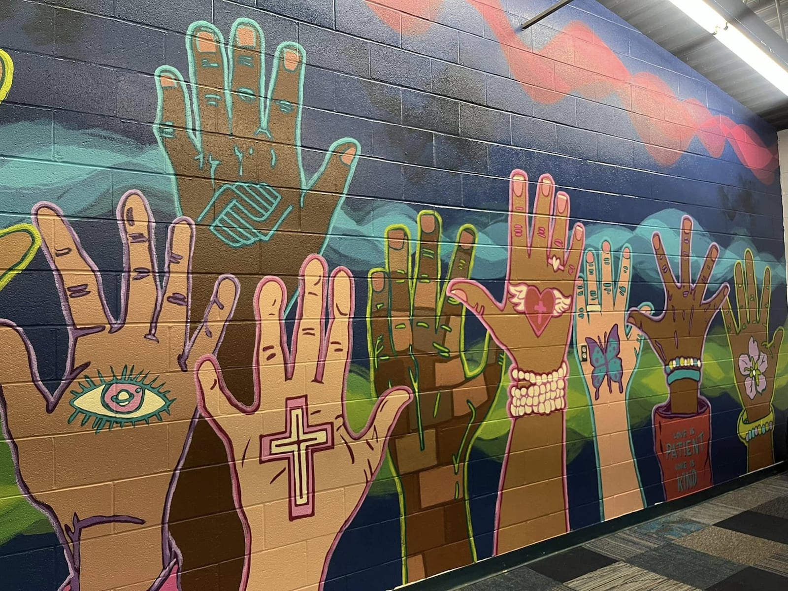 Artists with developmental disabilities and staff from InsideOut Studio in Hamilton, recently collaborated with teenagers from the Boys & Girls Club of Hamilton at the Grand Boulevard location to create a vibrant installation mural for their Teen Center. Inspiration Studios and Booker T. Washington Center are examples of organizations involved in the 2025 Holiday Giving Hub. 