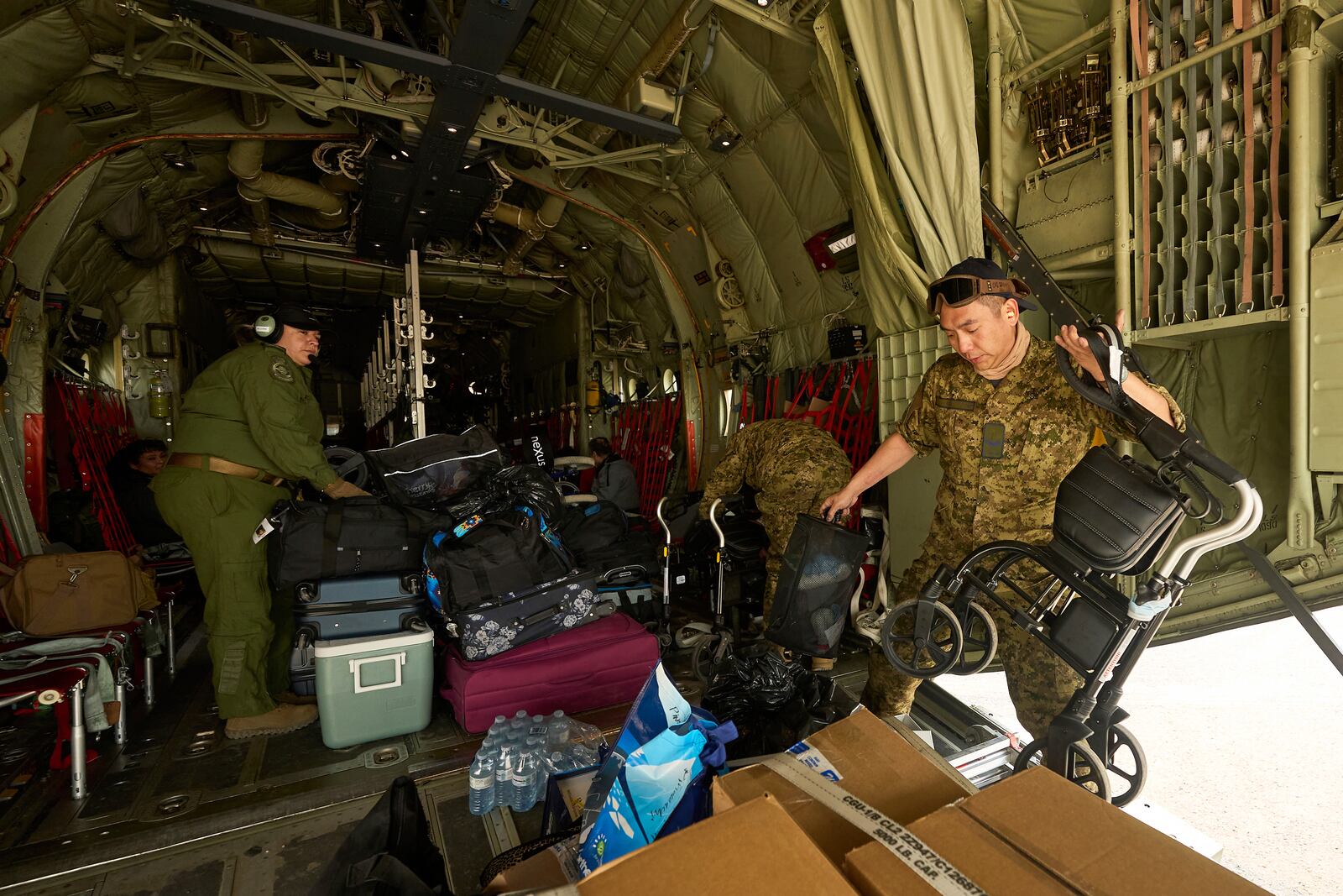 Royal Canadian Air Force Cpl. Ethan Cai helps load cargo as evacuees from Pinaow Wachi Care Home board a C-130 Hercules aircraft in Norway House, Manitoba, Tuesday, June 3, 2025, at the Norway House Airport as crews continue to fight wildfires in northern Manitoba. (David Lipnowski/The Canadian Press via AP)