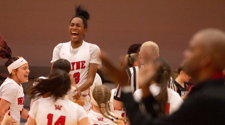 Wayne players lift teammate Bree Hall during their postgame celebration while head coach Travis Trice claps in the foreground. The Warriors defeated Mason 55-51 to advance to the Division I regional final. Jeff Gilbert/CONTRIBUTED