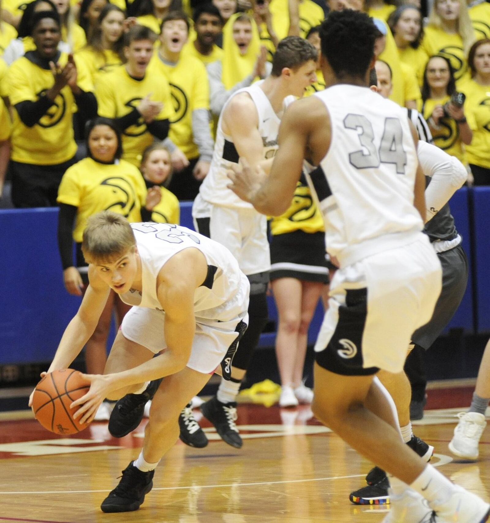 Lakota East’s Grant Spicer (33) picks up a loose ball in front of teammate Nate Johnson (34) during last Saturday’s 50-36 win over Fairmont in a Division I district basketball final at the University of Dayton Arena. MARC PENDLETON/STAFF
