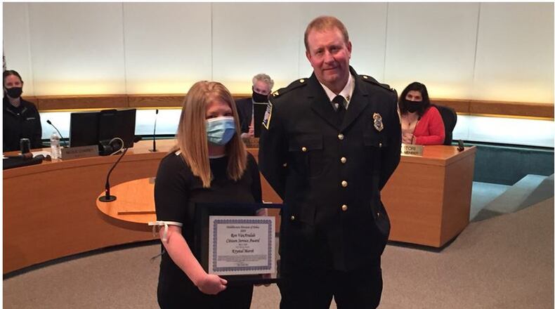 Krystal Marsh, left, was recognized for her outstanding efforts in calling 911 and giving Middletown police plenty of information after the CVS Pharmacy was robbed recently. Her efforts enabled police to spot the vehicle on Central Avenue and apprehend the robbery suspects just over the Ohio 122 bridge in Madison Twp. after they wrecked their vehicle. Police Chief David Birk, right, presented the police department’s appreciation and the Ron VanArsdale Citizen Service Award at the Middletown City Council meeting on June 2, 2020. ED RICHTER/STAFF