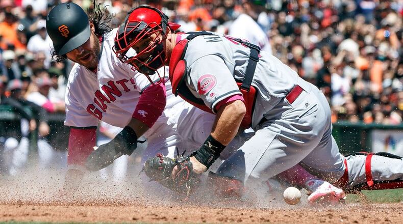 SAN FRANCISCO, CA - MAY 14: Brandon Crawford #35 of the San Francisco Giants scores a run ahead of a tag from Devin Mesoraco #39 of the Cincinnati Reds during the first inning at AT&T Park on May 14, 2017 in San Francisco, California. Players are wearing pink to celebrate Mother's Day weekend and support breast cancer awareness. (Photo by Jason O. Watson/Getty Images)