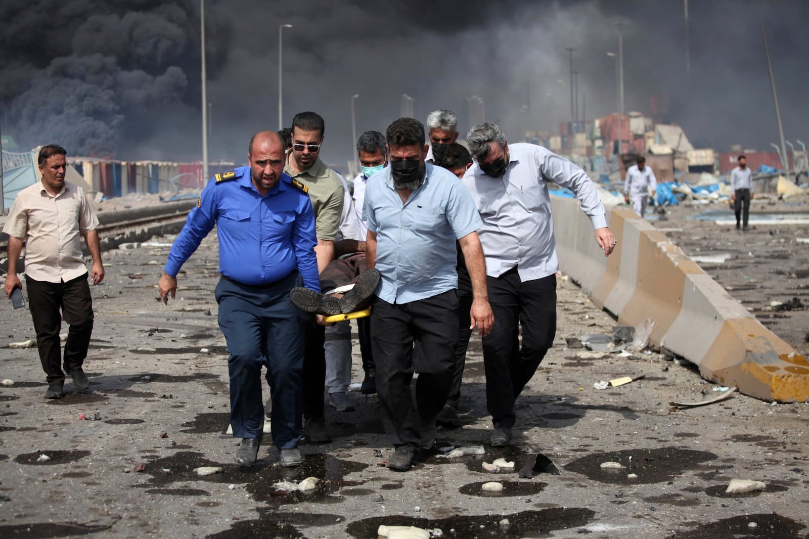 In this photo provided by Islamic Republic News Agency, IRNA, men carry an injured man after a massive explosion near the southern port city of Bandar Abbas, Iran, Saturday, April 26, 2025. (Mohammad Rasoul Moradi/IRNA via AP)
