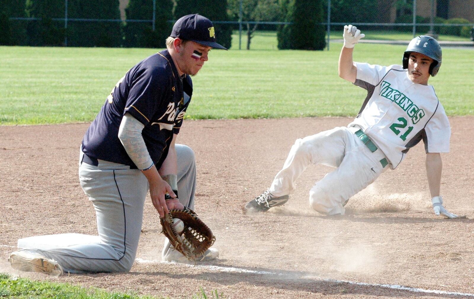 New Miami’s Noah Winkler (21) is about to be called safe at third base, beating the tag from Lockland’s Kyle Runk during Wednesday’s Division IV sectional baseball game at New Miami. The host Vikings won 8-1. RICK CASSANO/STAFF
