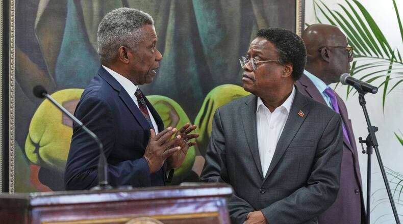 Chief of Protocol of the National Palace Marc Marie Yves Mazile speaks to Fritz Alphonse Jean, a member of Haiti’s transitional presidential council, before the start of a press conference in Port-au-Prince, Haiti, Tuesday, Nov. 25, 2025. (AP Photo/Odelyn Joseph)
