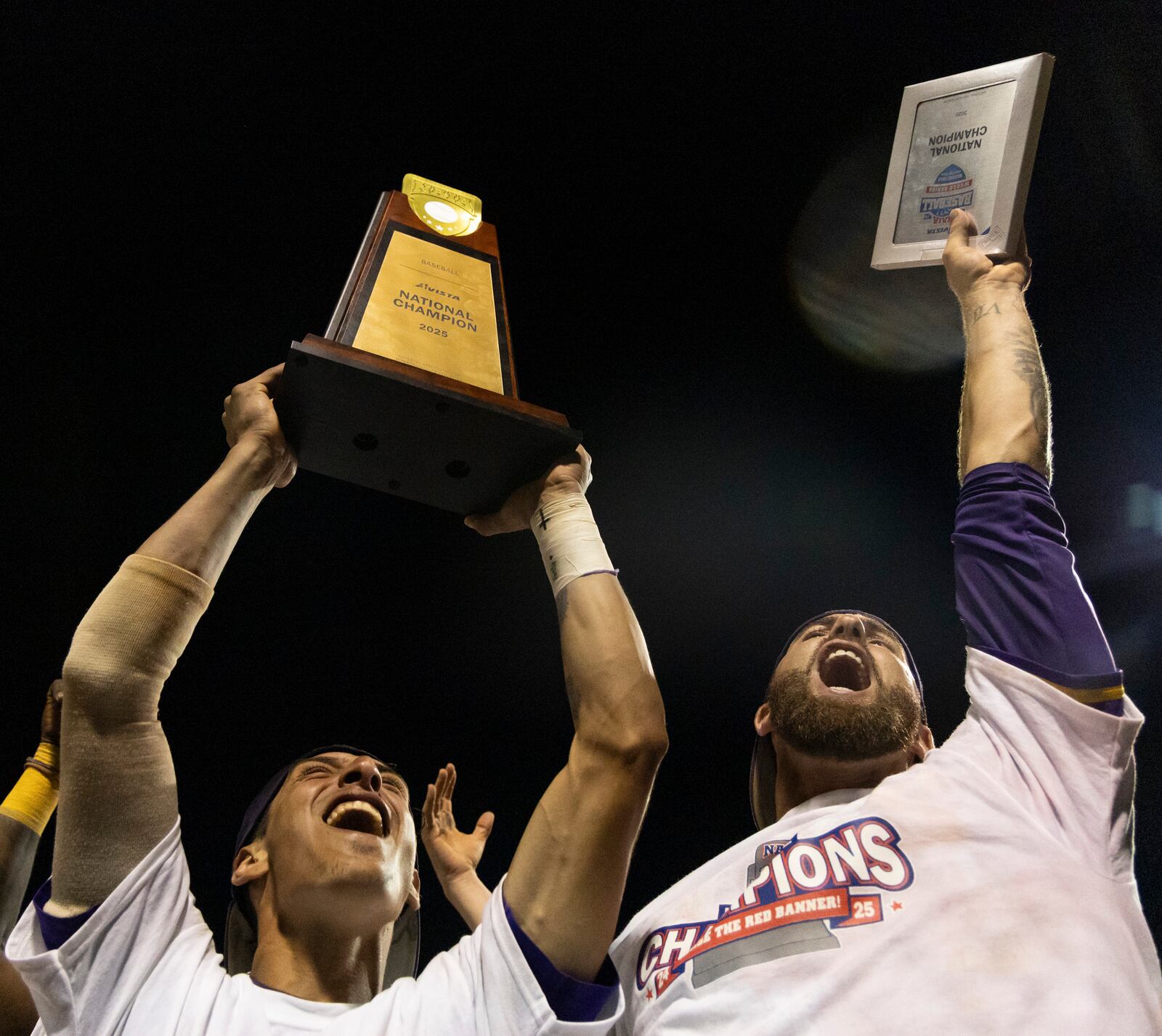 LSU Shreveport's Jose Sallorin, left, celebrates with the championship trophy after defeating Southeastern of Florida to win the championship game of the NAIA World Series colllege baseall game, Friday, May 30 2025, at Harris Field in Lewiston, Idaho. (Arthur H. Trickett-Wile/Lewiston Tribune via AP)