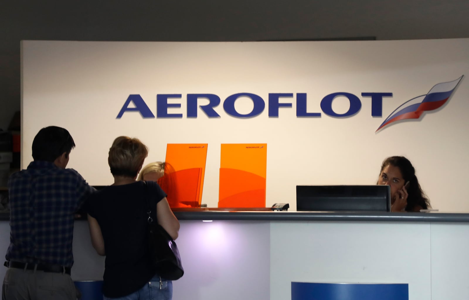 FILE - Customers stand by a counter of Russian airline Aeroflot at the airport in Prague, Czech Republic, Tuesday, July 2, 2019. (AP Photo/Petr David Josek, file)