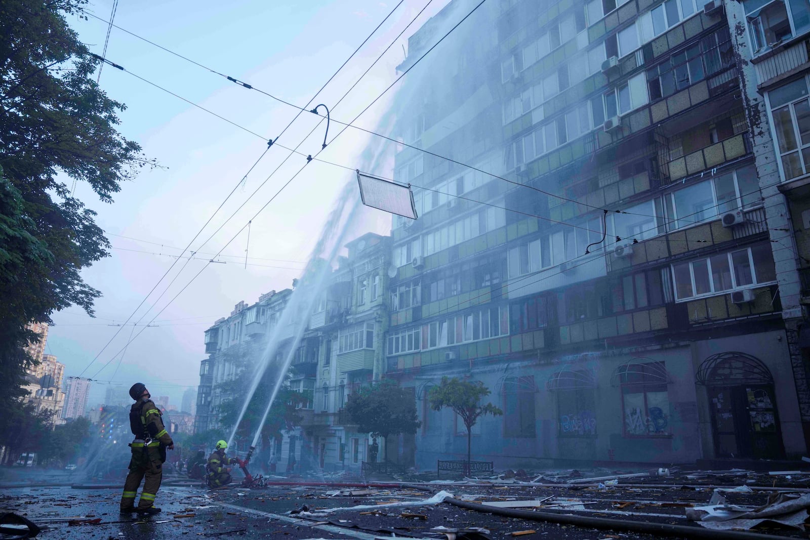 FILE - Rescue workers try to put out a fire at an apartment building heavily damaged by a Russian strike in Kyiv, Ukraine, on July 10, 2025. (AP Photo/Evgeniy Maloletka, File)