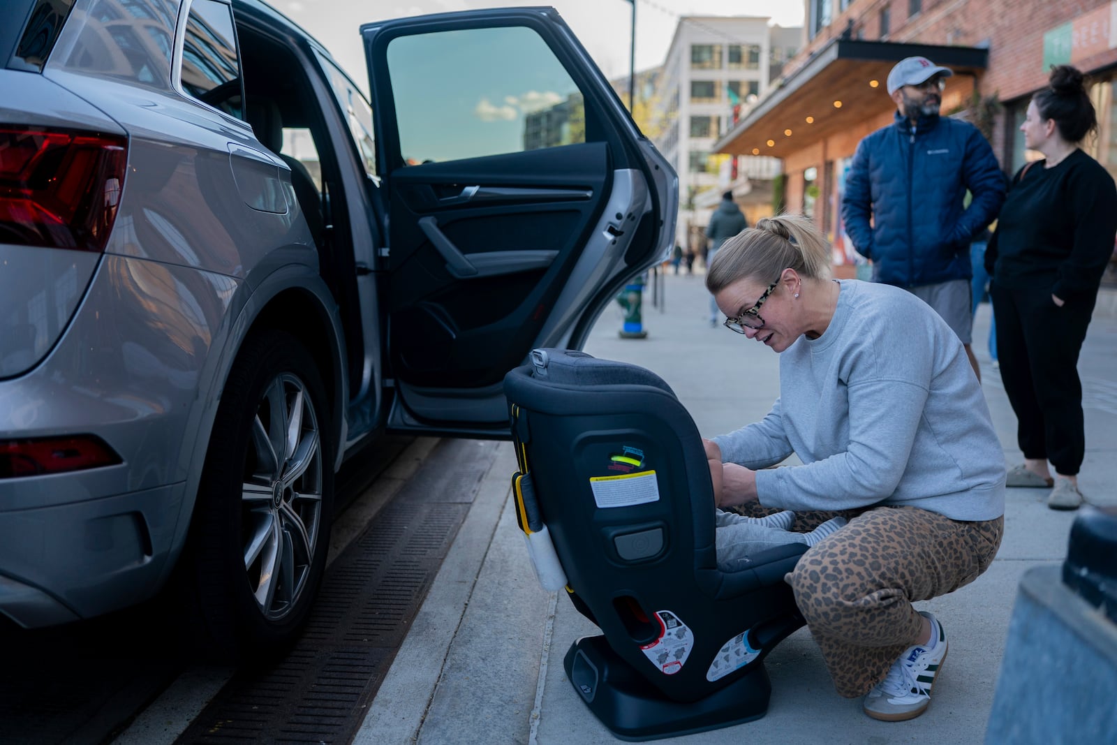 Elizabeth Mahon, owner of the baby store Three Littles, installs a new car seat for customers who made the purchase ahead of tarriff-driven price increases, at the Union Market location in Washington, on Wednesday, April 16, 2025. (AP Photo/Nathan Howard)