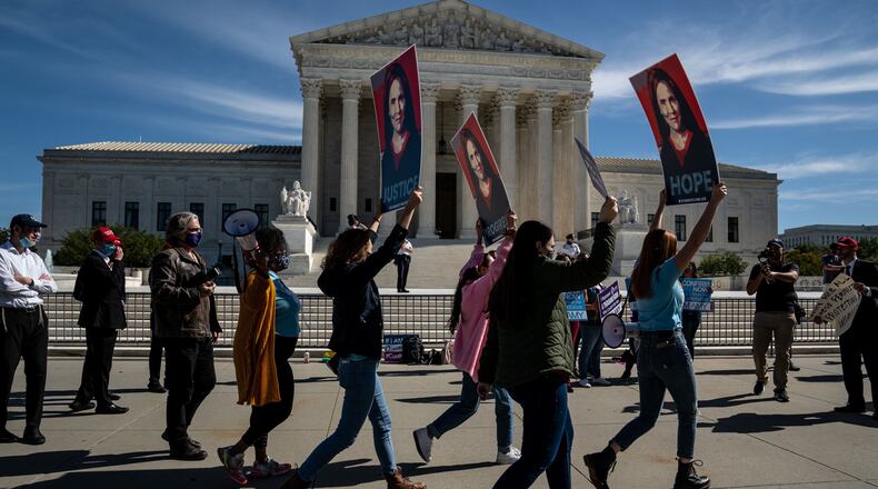 Supporters of Judge Amy Coney Barrett, President Donald Trump's Nominee for Supreme Court, stand outside the Supreme Court in Washington, Oct. 14, 2020. Warnings from Democrats that Republicans and their Supreme Court nominee threaten the Affordable Care Act elicited reassuring words from both Sen. Lindsey Graham (R-S.C.) and Barrett. (Anna Moneymaker/The New York Times)