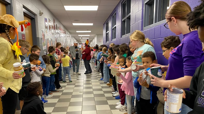 For more than a decade Middletown’s Central Elementary has made packing Thanksgiving meals and other items for needy local families a total school event.
The school’s annual “Turkey Pass” sees hundreds of the students line up in the school’s main hallway leading to the cafeteria and then each donated Thanksgiving food and care item is passed from one student’s hands to another. (Photo By Michael D. Clark/Journal-News)