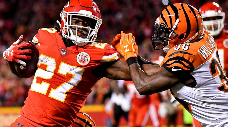 Kareem Hunt (left) of the Kansas City Chiefs stiff arms Shawn Williams of the Cincinnati Bengals on his way to a diving touchdown during the second quarter of the game at Arrowhead Stadium on October 21, 2018 in Kansas City, Kansas. (Photo by Peter Aiken/Getty Images)