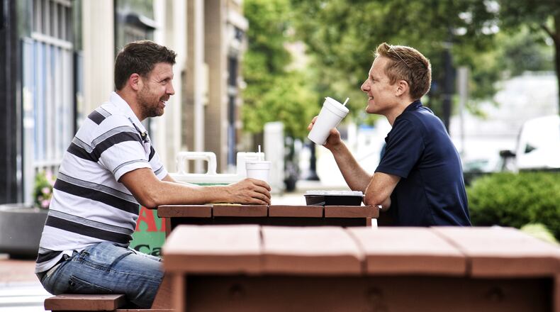 Matt Tucker, left, and Rick Meyer eat lunch at the picnic tables set up for outdoor dining along High Street in downtown Hamilton Thursday, Sept. 3, 2020. NICK GRAHAM / STAFF