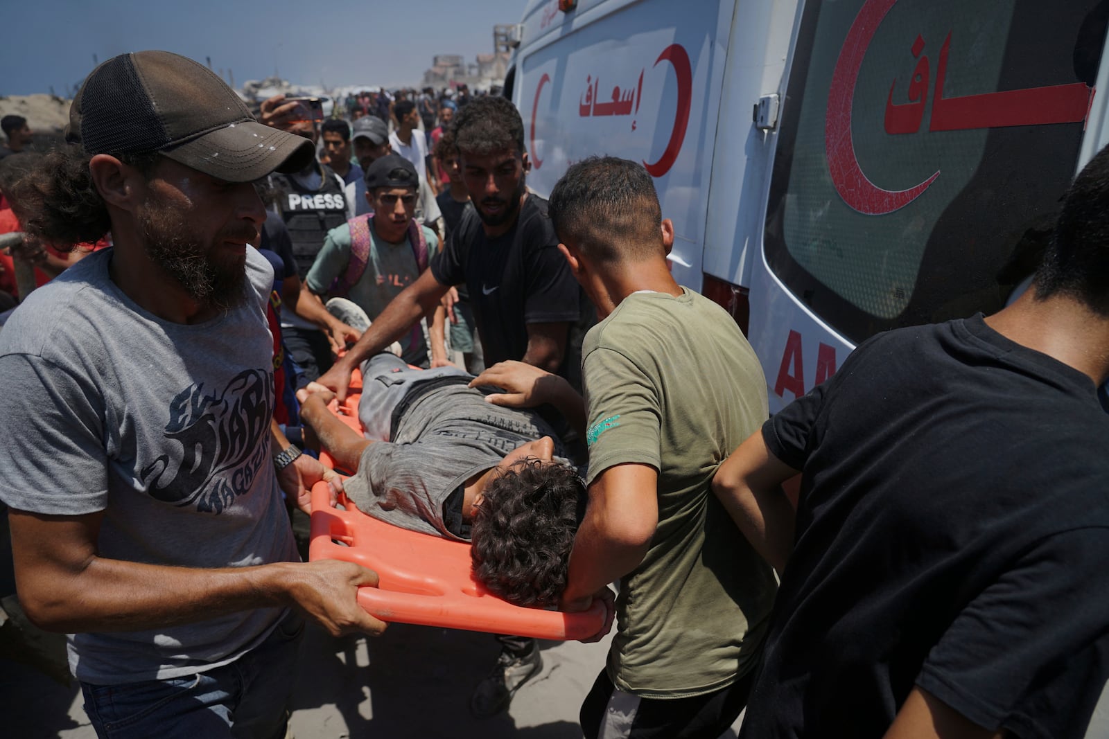 Injured Palestinians are transferred to an ambulance after being wounded while waiting for aid arriving from the northern Gaza Strip, in Gaza City, Tuesday, July 22, 2025. (AP Photo/Jehad Alshrafi)