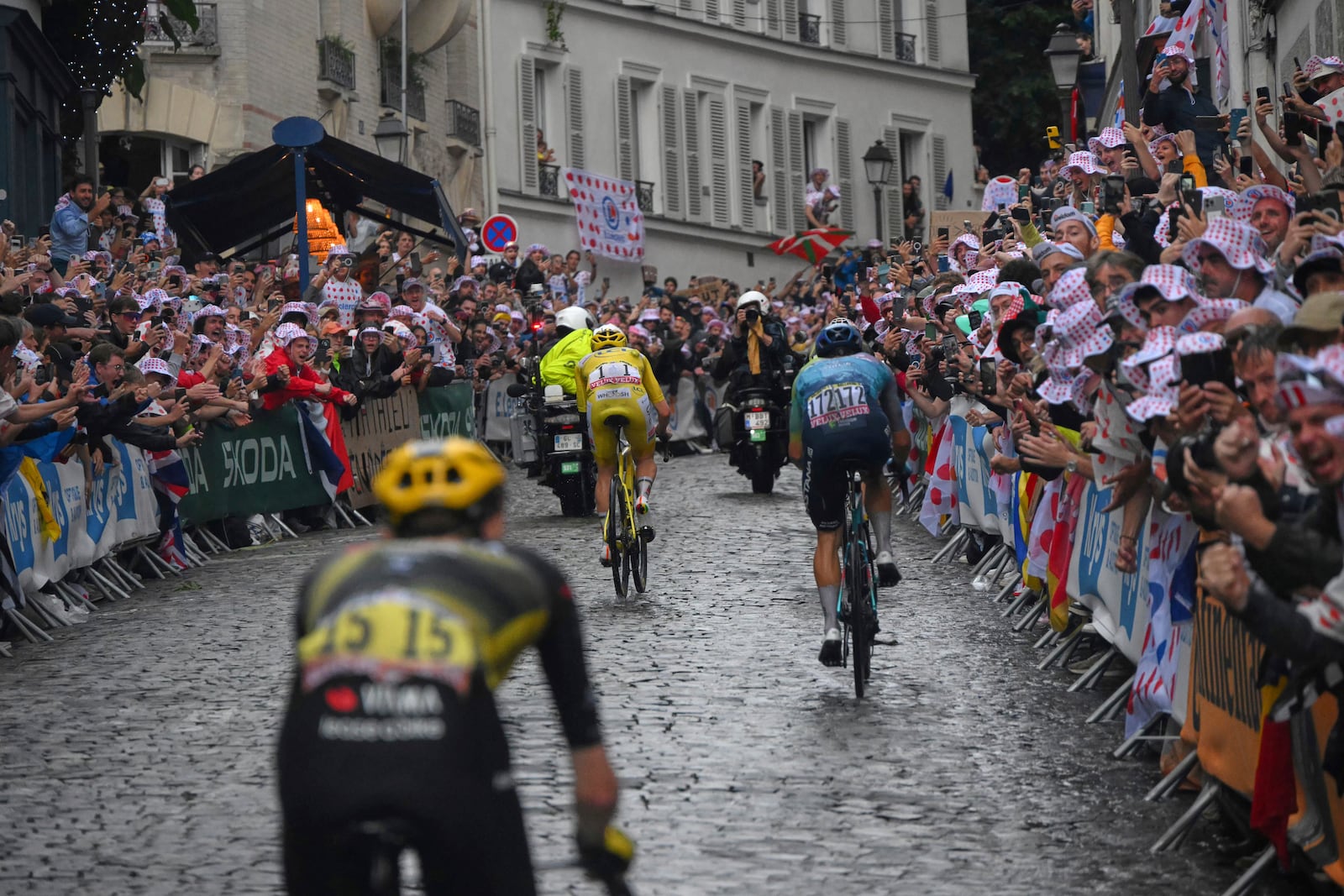 The stage leaders, including race winner Slovenia's Tadej Pogacar, wearing the overall leader's yellow jersey, race through the cobbled streets of Montmartre during the twenty-first stage of the Tour de France cycling race over 132.3 kilometers (82.1 miles) with start in Mantes-la-Ville and finish on the Champs-Elysees in Paris, France, Sunday, July 27, 2025. (Bernard Papon, Pool Photo via AP)