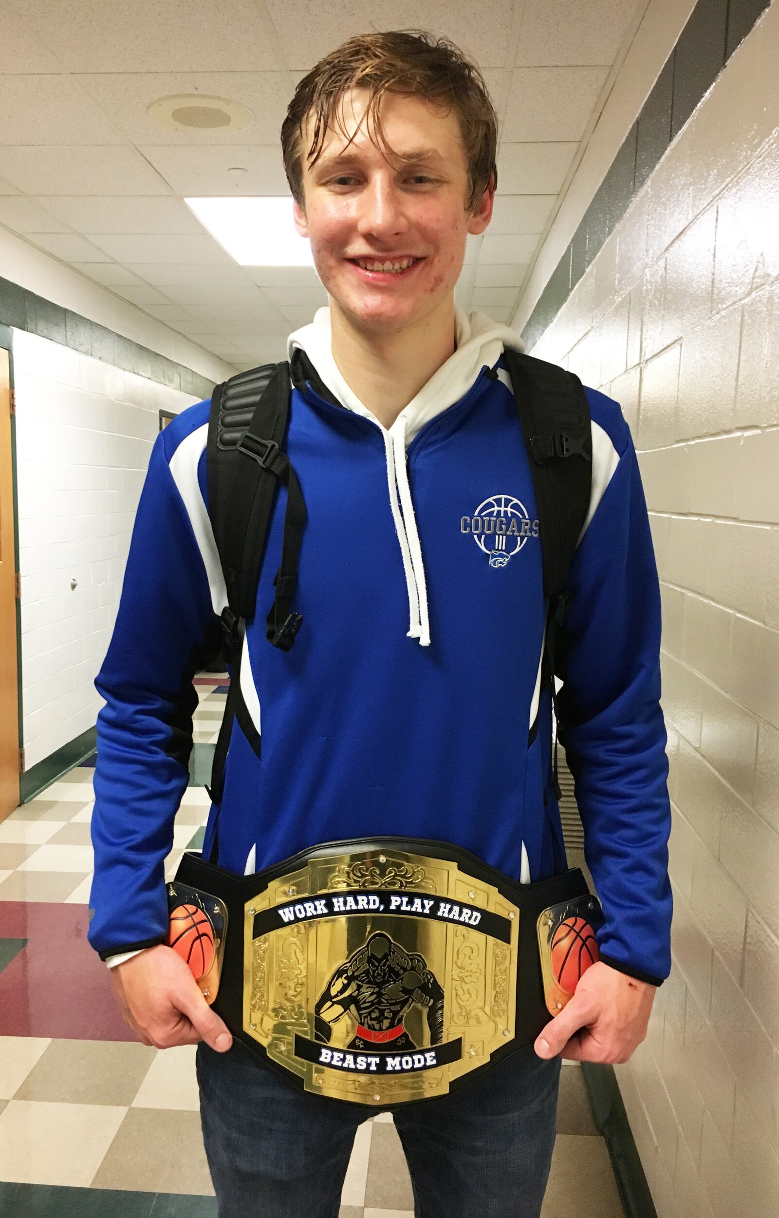 Cincinnati Christian’s Riley Reutener poses with the “Beast Mode” belt Friday night after the Cougars won 70-52 at New Miami. RICK CASSANO/STAFF
