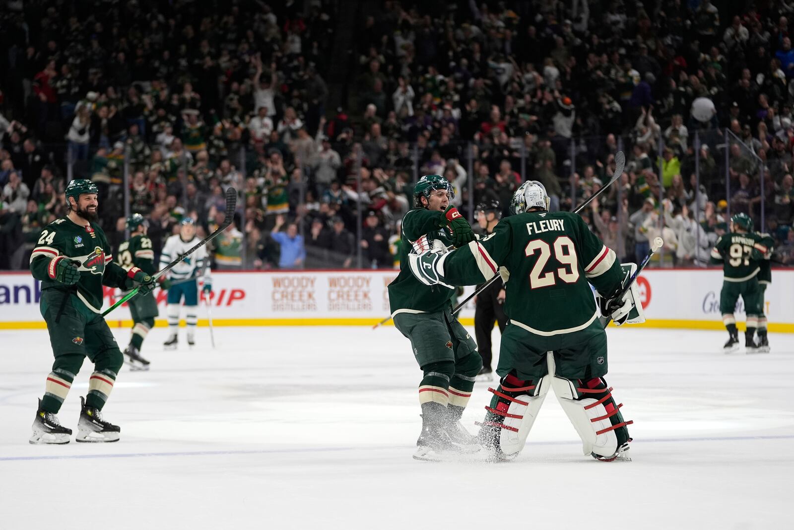 Minnesota Wild defenseman Brock Faber (7), center, and goaltender Marc-Andre Fleury (29) celebrate after the overtime win against the San Jose Sharks of an NHL hockey game, Wednesday, April 9, 2025, in St. Paul, Minn. (AP Photo/Abbie Parr)