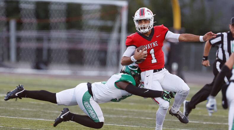 Wayne quarterback Tyrell Lewis tries to avoid a tackle by Northmont's Terrance Harrell as he rolls out and looks for an open receiver. BILL LACKEY/STAFF