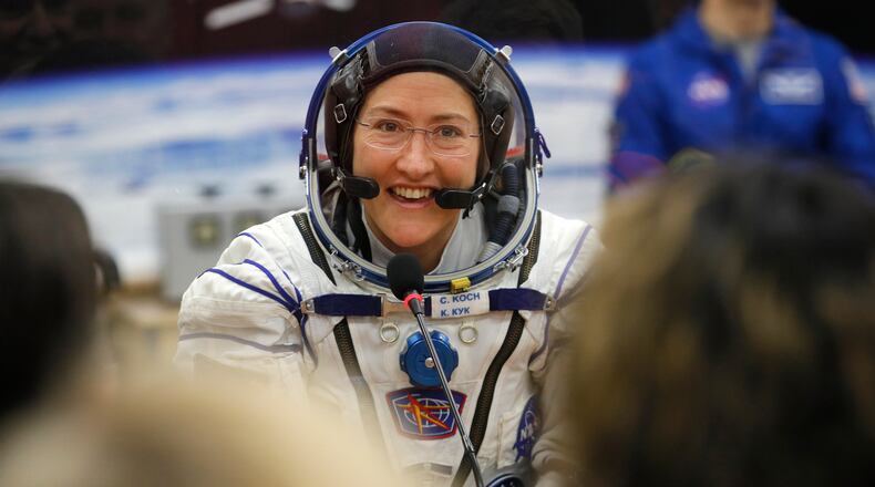 FILE - In this Thursday, March 14, 2019 file photo, U.S. astronaut Christina Koch, member of the main crew of the expedition to the International Space Station (ISS), speaks with her relatives through a safety glass prior the launch of Soyuz MS-12 space ship at the Russian leased Baikonur cosmodrome, Kazakhstan. Koch told The Associated Press on Tuesday, Jan. 28, 2020, her 319th consecutive day in space _ that taking part in the first all-female spacewalk was the highlight of her mission. She's been living on the International Space Station since March and returns to Earth on Feb. 6, landing in Kazakhstan with two colleagues aboard a Russian capsule. (AP Photo/Dmitri Lovetsky, Pool)