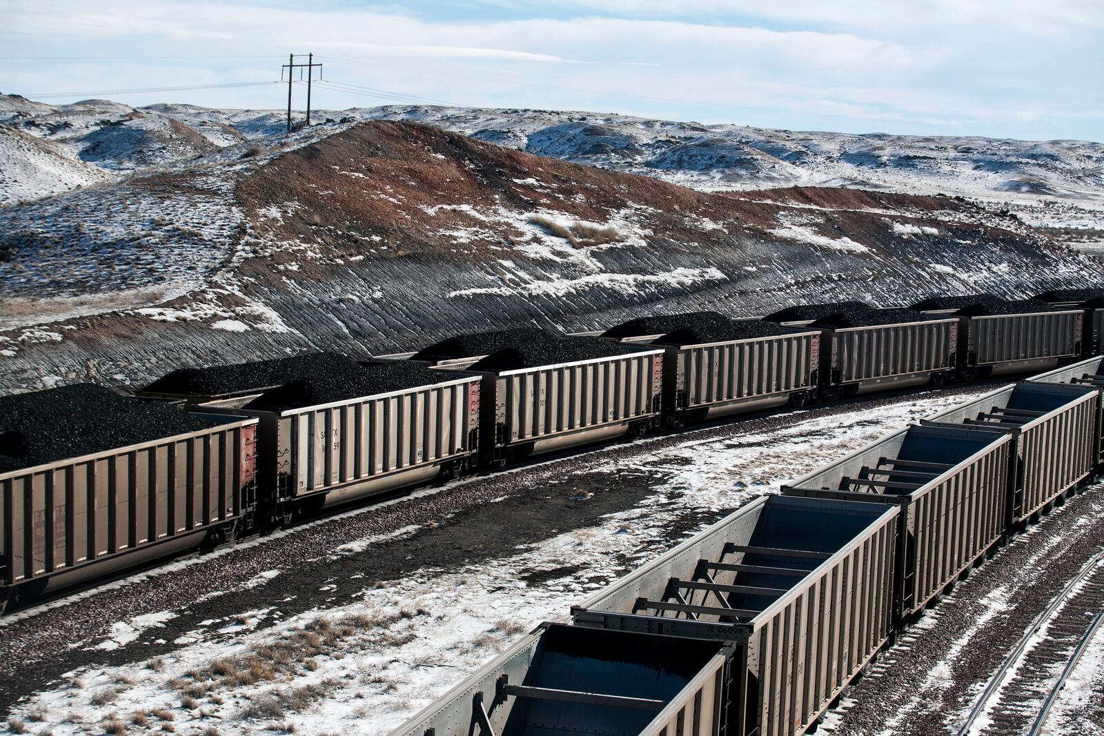 FILE - Rail cars are filled with coal and sprayed with a topper agent to suppress dust north of Douglas, Wyo,, Jan. 9, 2014. (Ryan Dorgan/Casper Star-Tribune via AP, File)