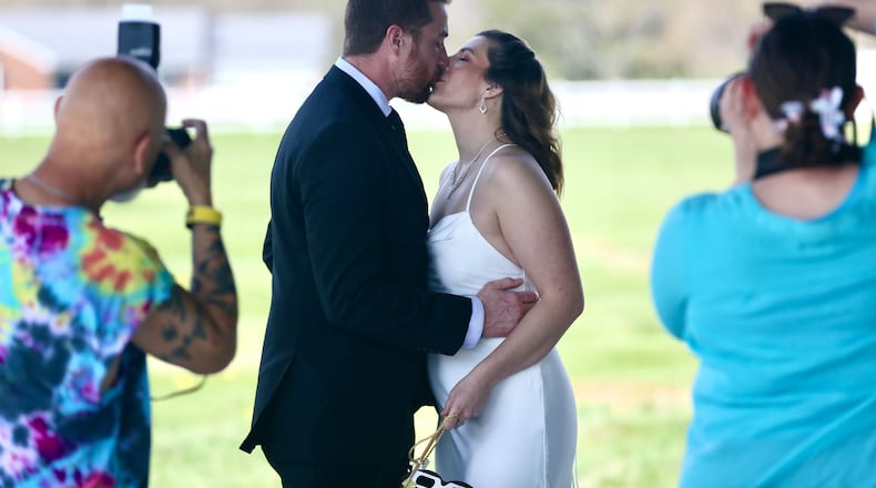 Gerald Lester and Samantha Palmer take photos before their wedding ceremony at Trenton Community Park during the total solar eclipse on Monday, April 8, 2024. GREG LYNCH/STAFF