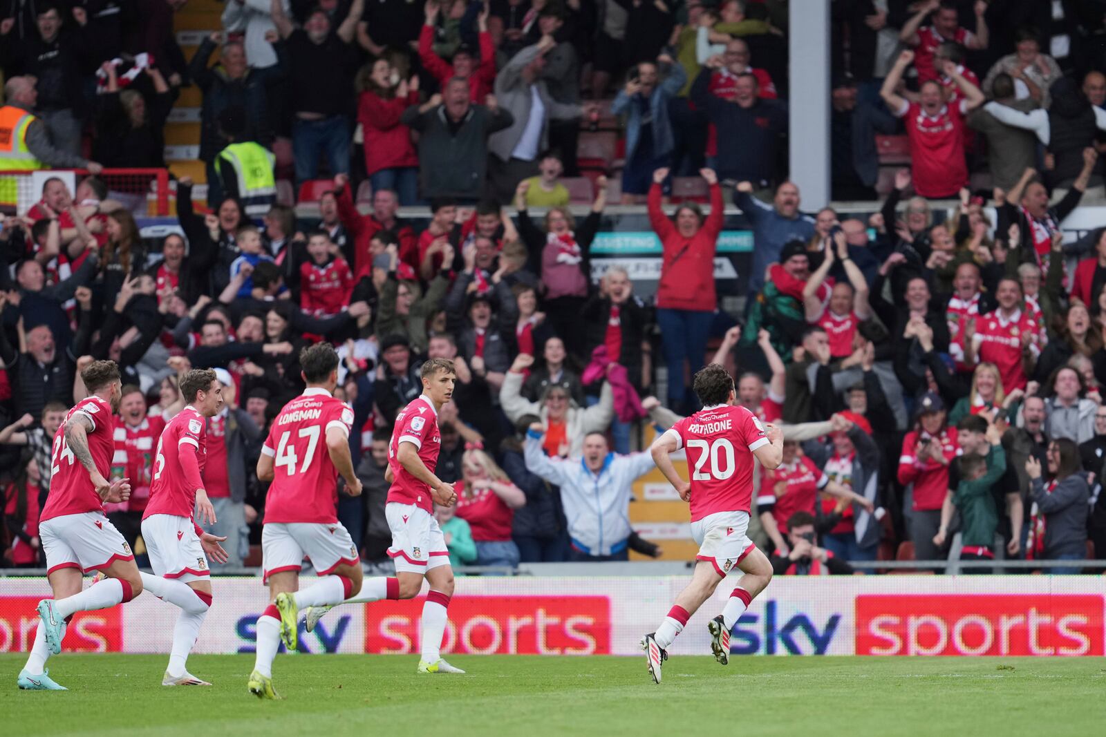 Wrexham's Oliver Rathbone, right, celebrates with teammates after scoring his side's opening goal during the English League One soccer match between Wrexham and Charlton Athletic at the Racecourse ground in Wrexham, Wales, Saturday, April 26, 2025. (AP Photo/Jon Super)