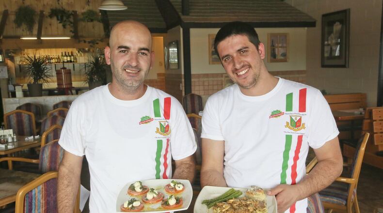 Labi Troni and Mensur Demnika, chefs at Palermo’s Italian Restaurant in West Chester Twp., hold dishes capresi salad and veal marsala at the restaurant, Wednesday, May 26, 2015. GREG LYNCH / STAFF