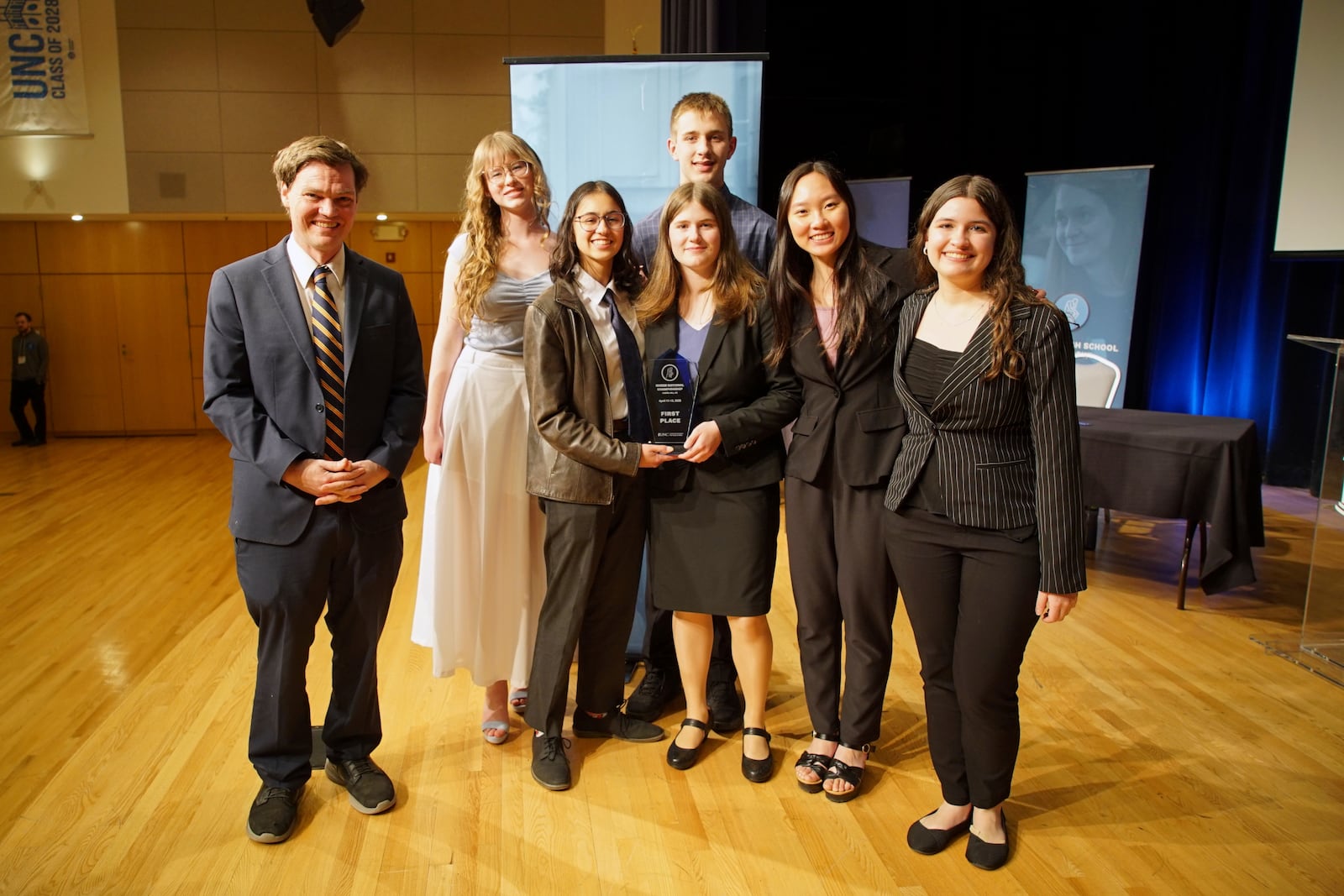 From left, students Luke Calhoun, Olivia Beazer, Sona Zarkou, Mae Bradford, front, Lincoln Bradford, back, Cindy Huang and Juliana Migliati from Arizona's BASIS Flagstaff Charter School pose with the first place trophy after winning the National High School Ethics Bowl in Chapel Hill, N.C., on Sunday, April 13, 2025. (AP Photo/Allen G. Breed)