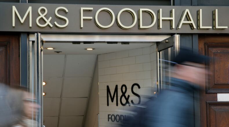 People walk past a branch of British clothing and food store Marks and Spencer in London, Wednesday, May 23, 2018. (AP Photo/Alastair Grant)