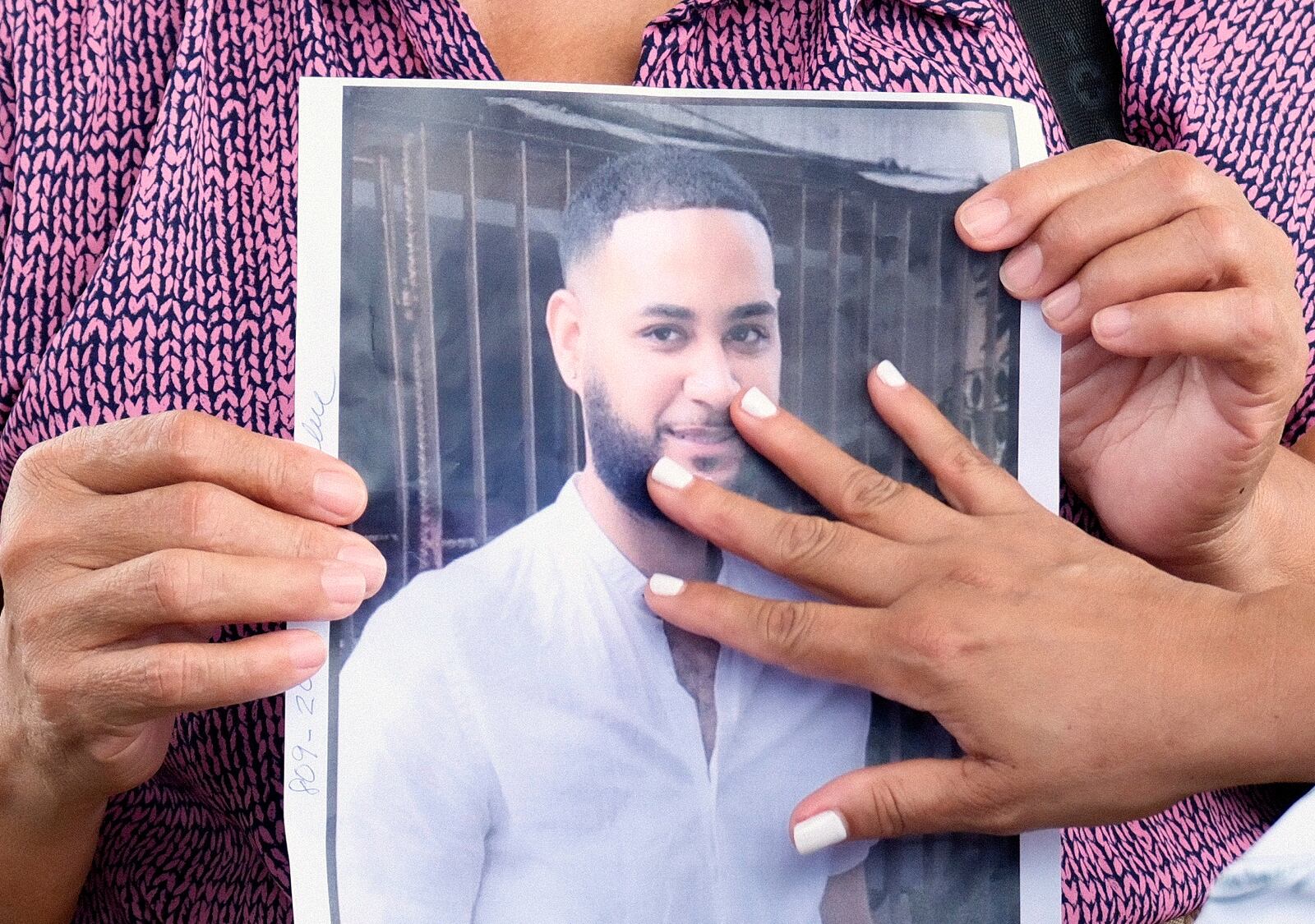 A woman touches a photo of one of the missing during the search for survivors at the Jet Set nightclub after its roof collapsed two nights prior during a merengue concert in Santo Domingo, Dominican Republic, Wednesday, April 9, 2025. (AP Photo/Ricardo Hernandez)