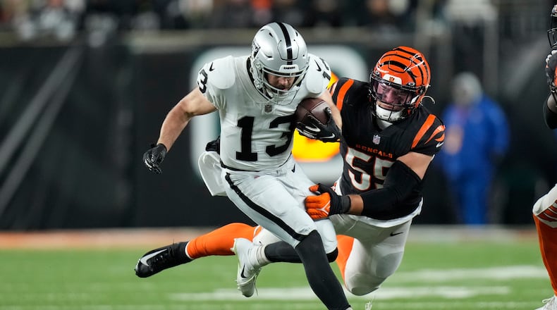 Las Vegas Raiders' Hunter Renfrow (13) is tackled by Cincinnati Bengals' Logan Wilson (55) during the second half of an NFL wild-card playoff football game, Saturday, Jan. 15, 2022, in Cincinnati. (AP Photo/AJ Mast)