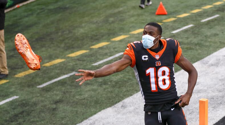 Cincinnati Bengals wide receiver A.J. Green (18) tosses a cleat to a fan after an NFL football game against the Baltimore Ravens, Sunday, Jan. 3, 2021, in Cincinnati. (AP Photo/Aaron Doster)