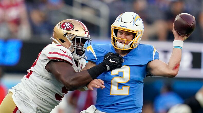 Los Angeles Chargers quarterback Easton Stick, right, is pressured by San Francisco 49ers defensive end Zach Kerr during the first half of a preseason NFL football game Sunday, Aug. 22, 2021, in Inglewood, Calif. (AP Photo/Ashley Landis)