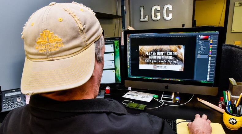 Thommy Long with LemonGrenade Creative shows off one of the social media images they have created for local businesses looking to stay connected to their customers during the coronavirus pandemic. LemonGrenade has donated time to helped create social media cards for over 30 local businesses so far. NICK GRAHAM / STAFF