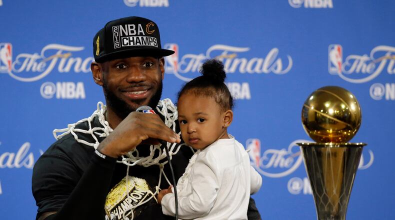 The Cavaliers’ LeBron James answers questions as he holds his daughter Zhuri during a post-game press conference after Game 7 on Sunday, June 19, 2016, in Oakland, Calif. (AP Photo/Eric Risberg)