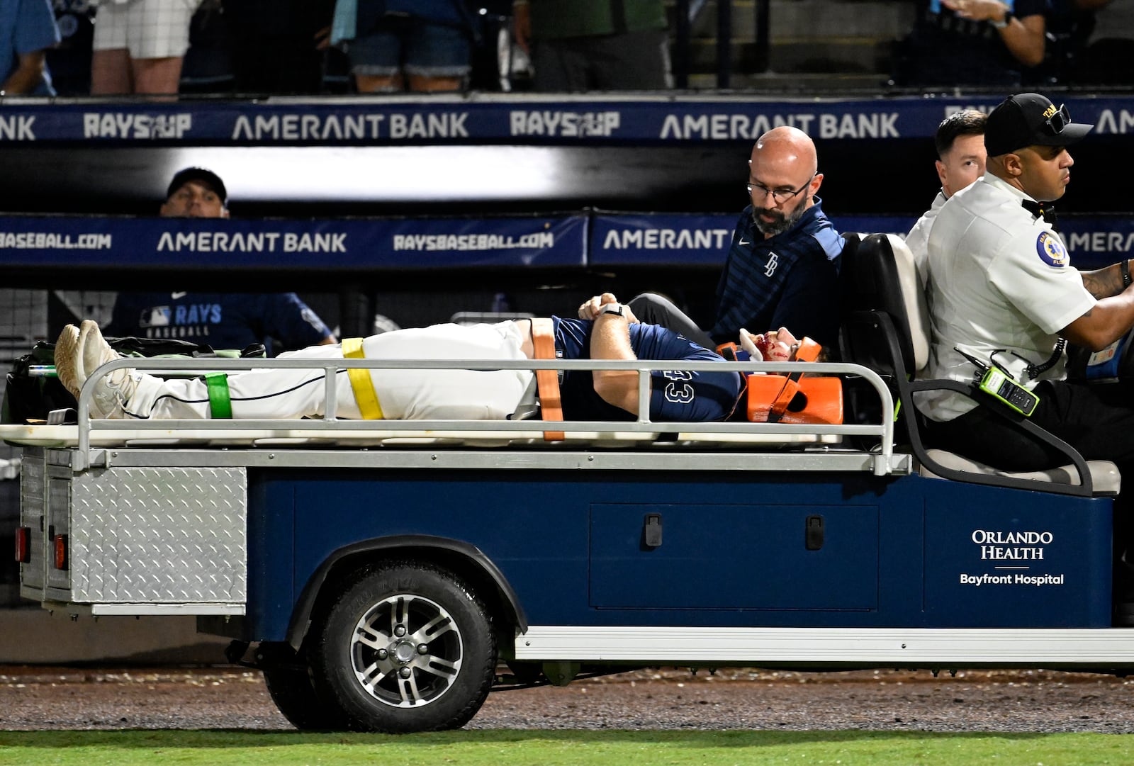 Tampa Bay Rays' Hunter Bigge is taken off the field after being hit by a foul ball while in the dugout during the seventh inning of a baseball game against the Baltimore Orioles, Thursday, June 19, 2025, in Tampa, Fla. (AP Photo/Jason Behnken)